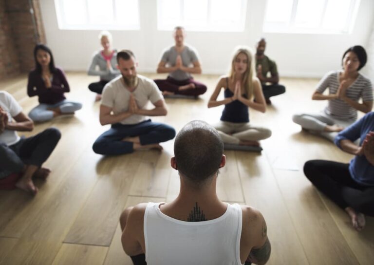 A group of people meditating in a yoga class.