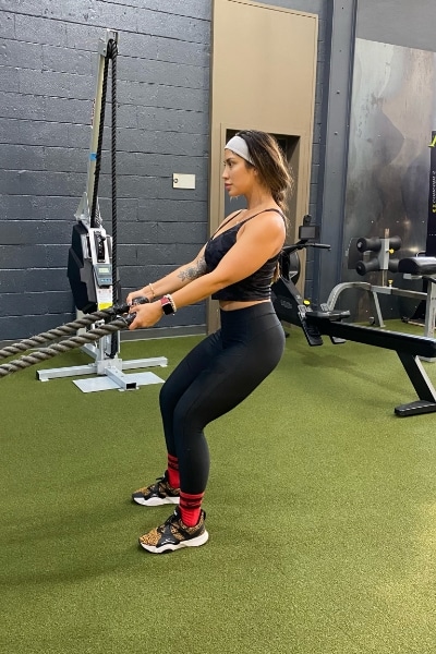 A woman doing a squat in a gym.