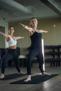 Two women doing yoga in a gym.