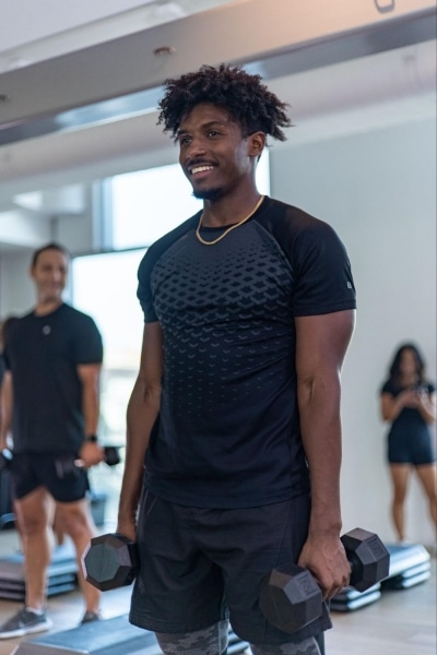 man curling dumbells in studio at fit athletic