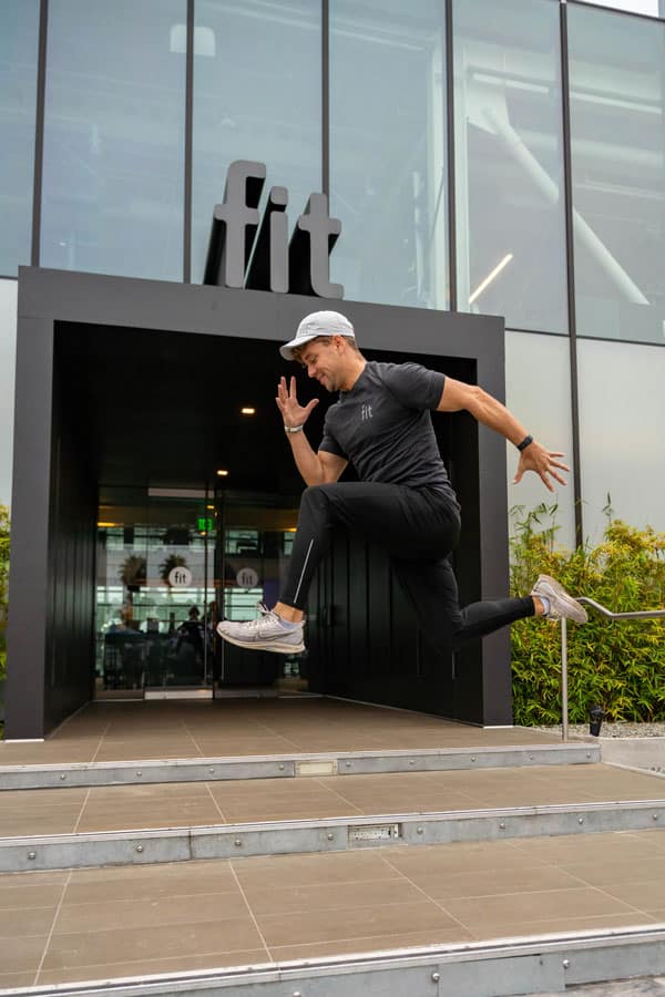 A man jumping in front of a building.