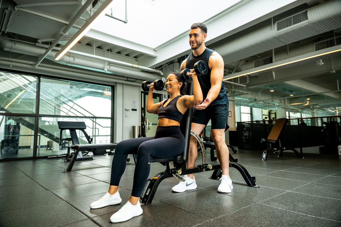 A man and woman working out in a gym.