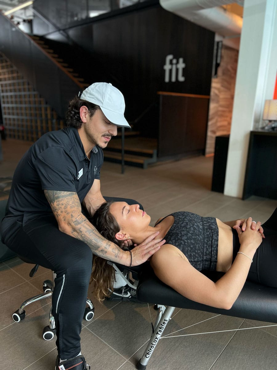 A woman is being helped by a physical therapist in a gym.