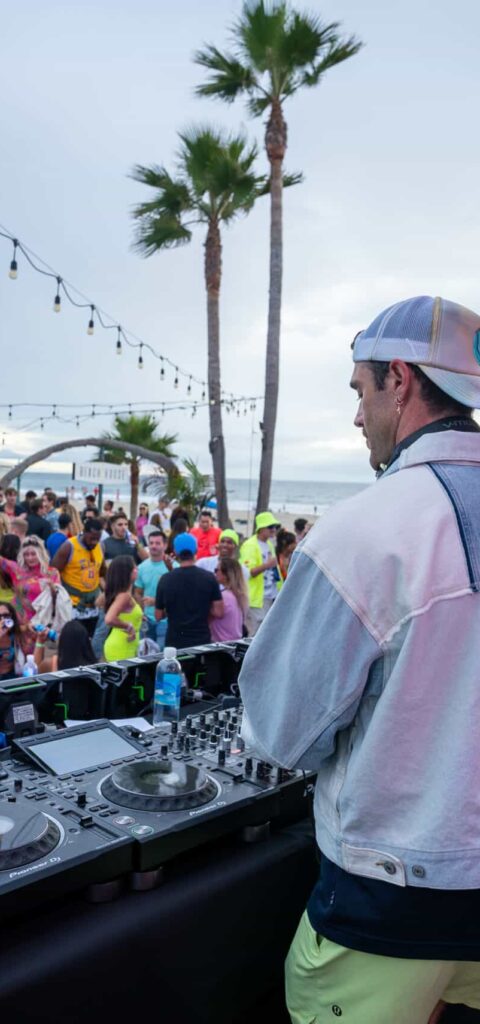 A man is djing at a beach party.