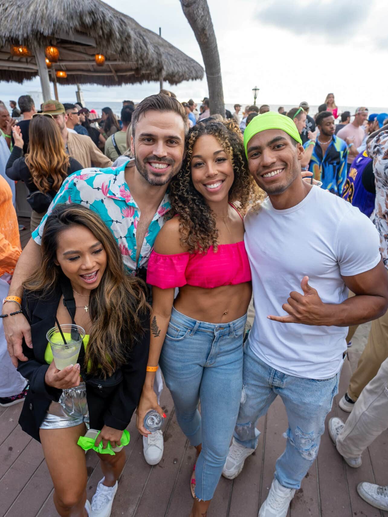 A group of people posing for a photo at a beach party.